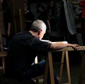 Zajęcia na kursie rysunku - kursanci rysujący pozujacego modela